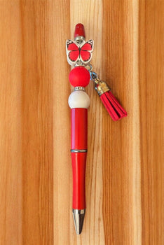 Red pen with butterfly charm and tassel