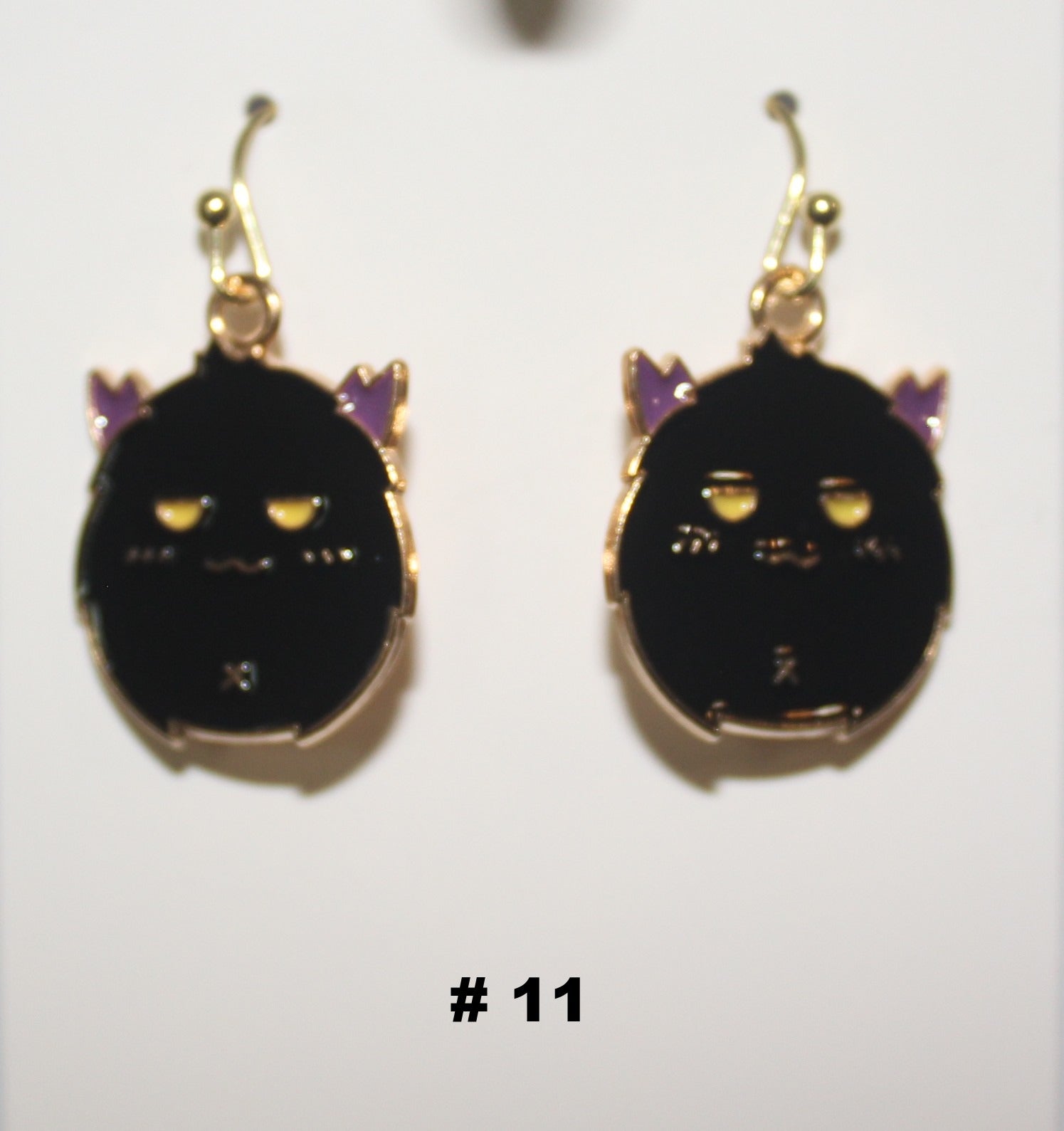 Black cat-shaped handmade earrings with gold accents 
