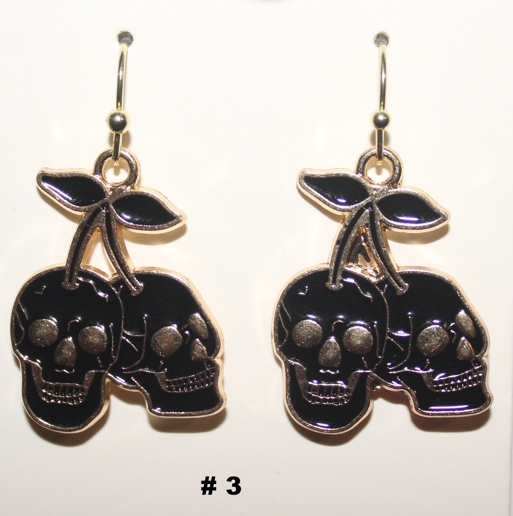 Skull-shaped earrings with black and gold details 