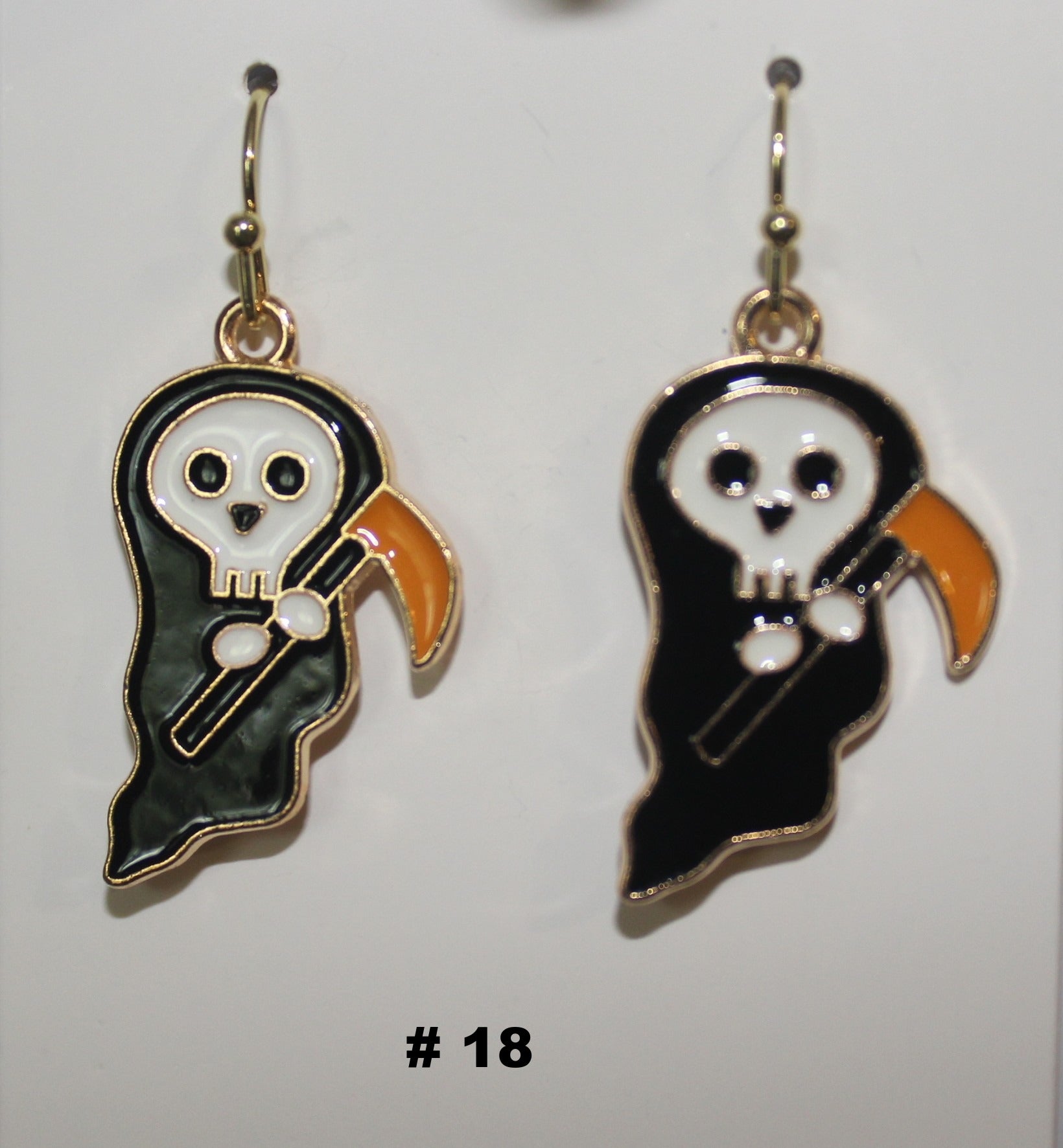 Pair of ghost-shaped earrings with a white face and black body