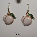 Pair of peach-shaped earrings with gold and green accents 