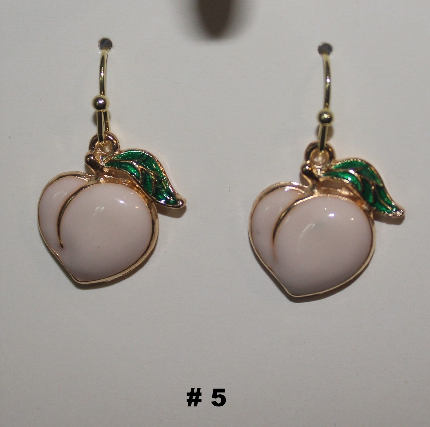 Pair of peach-shaped earrings with gold and green accents 