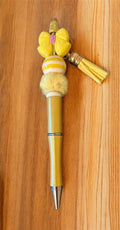 Decorative pen with yellow accents and tassels 