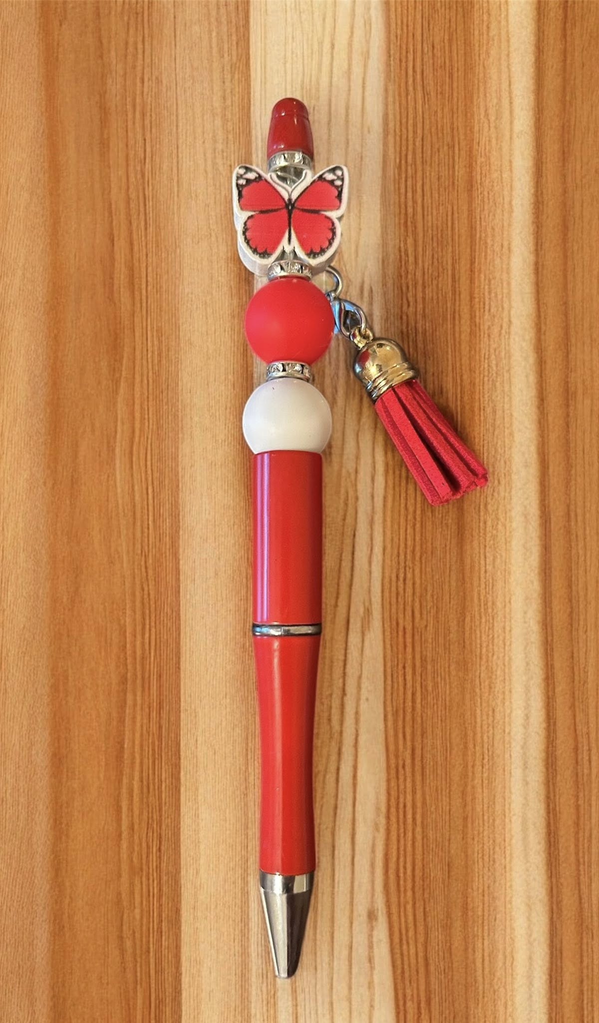 Red pen with butterfly charm and tassel 