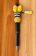 Decorative pen with yellow bead and black and white striped design 