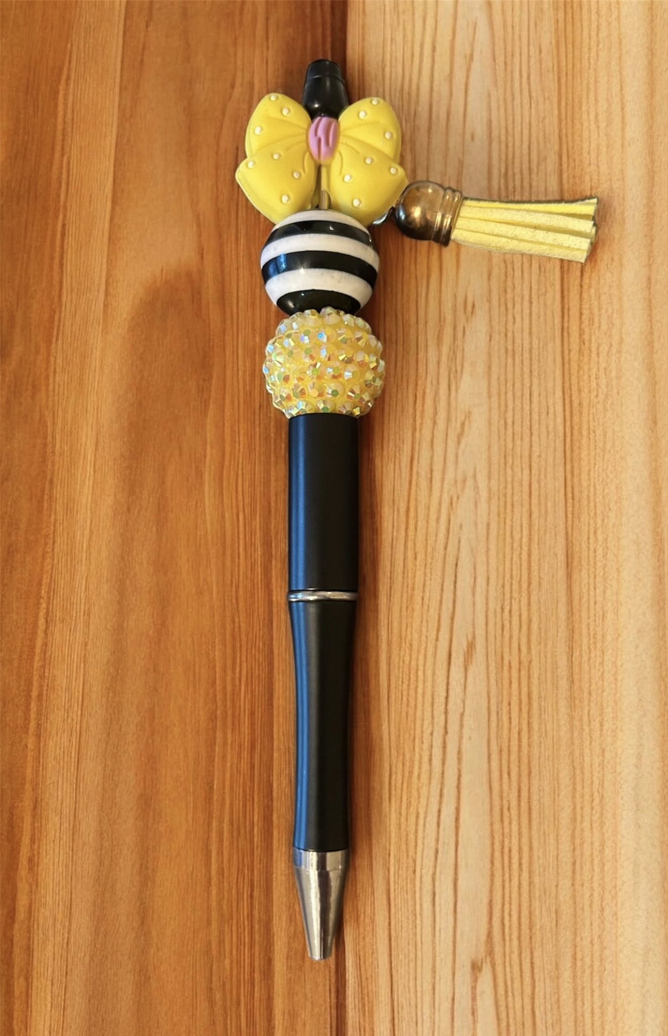 Decorative pen with yellow bead and black and white striped design 
