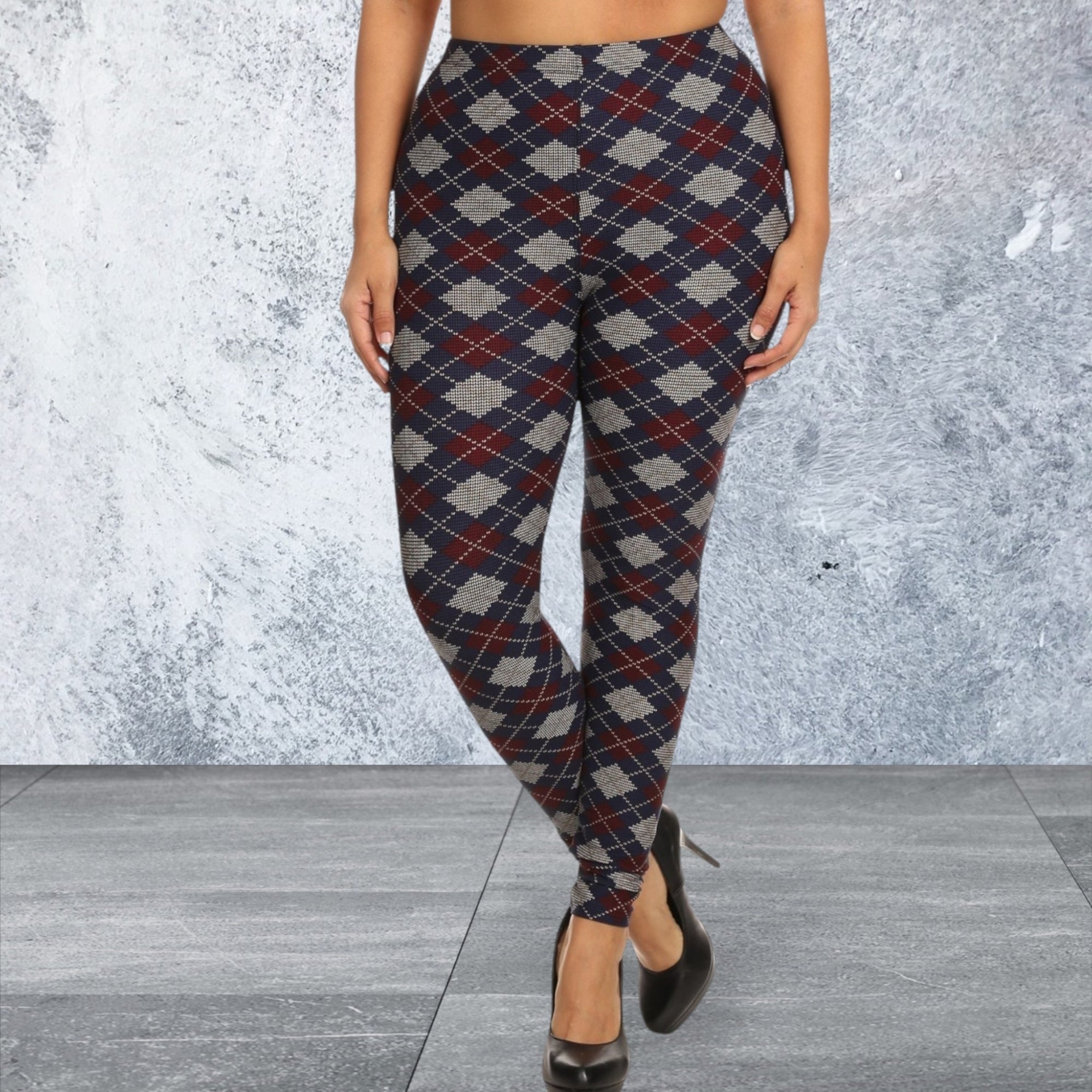 Plaid patterned leggings worn by a person against a textured gray wall.