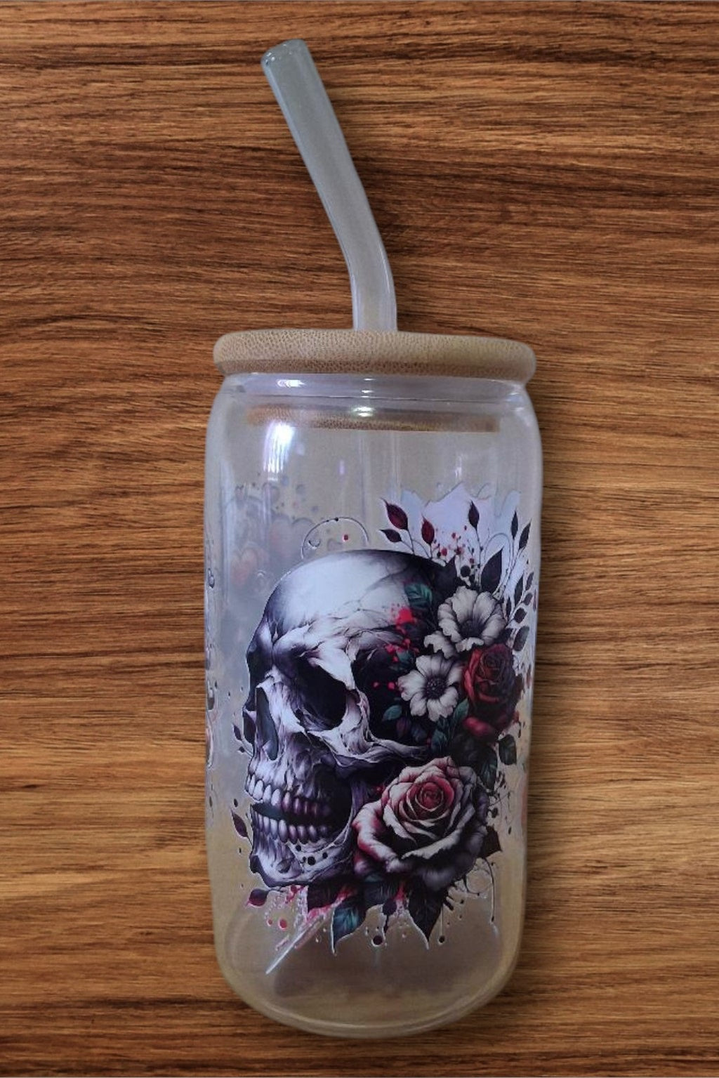 Clear glass tumbler with a skull and floral design 