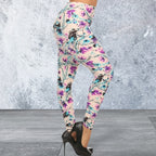 Colorful floral leggings worn by a person against a textured gray wall.