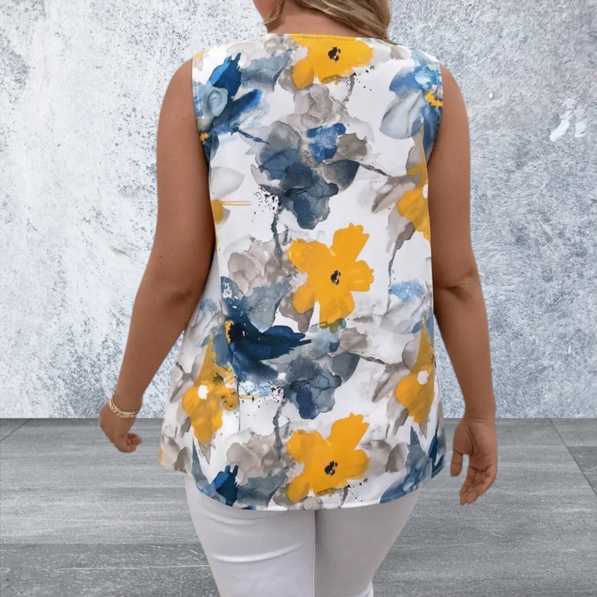 Woman wearing a sleeveless floral top with yellow and blue flowers 