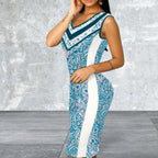 Woman wearing a blue and white patterned dress against a gray concrete wall.