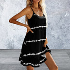 Woman wearing a black dress with white patterns against a gray textured wall.