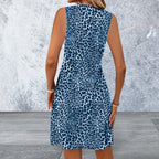 Woman wearing a blue leopard print dress against a textured wall.