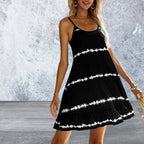 Woman wearing a black dress with white patterns against a gray textured wall.