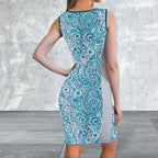 Woman wearing a blue patterned dress against a gray concrete wall.